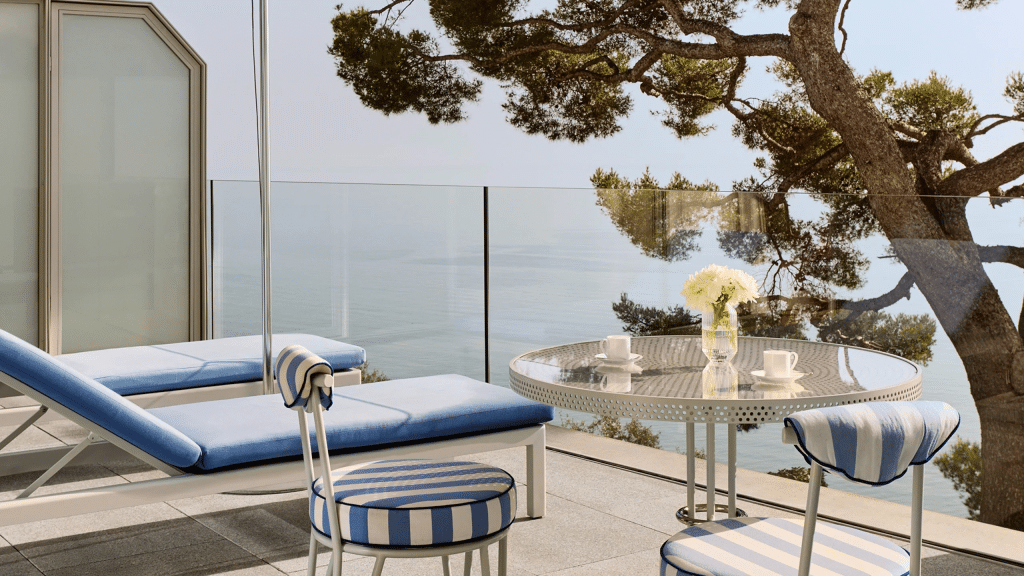 Minimalist luxury hotel terrace overlooking the sea, emphasizing calm, space, and visual focus in high-end design.